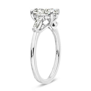Beautiful three stone engagement ring with trellis set 2ct oval cut lab grown diamond amid baguette side stones in 14k white gold shown from side