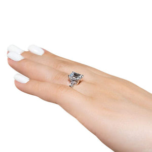 Baguette side stone engagement ring with 1ct emerald cut lab grown diamond in 14k white gold with peek-a-boo diamonds worn on hand