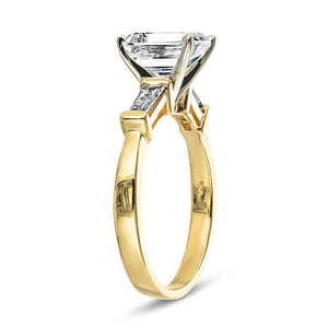 Modern three stone engagement ring with two baguette cut recycled diamond side stones and a 1.5ct emerald cut lab grown diamond center in 14k yellow gold shown from side