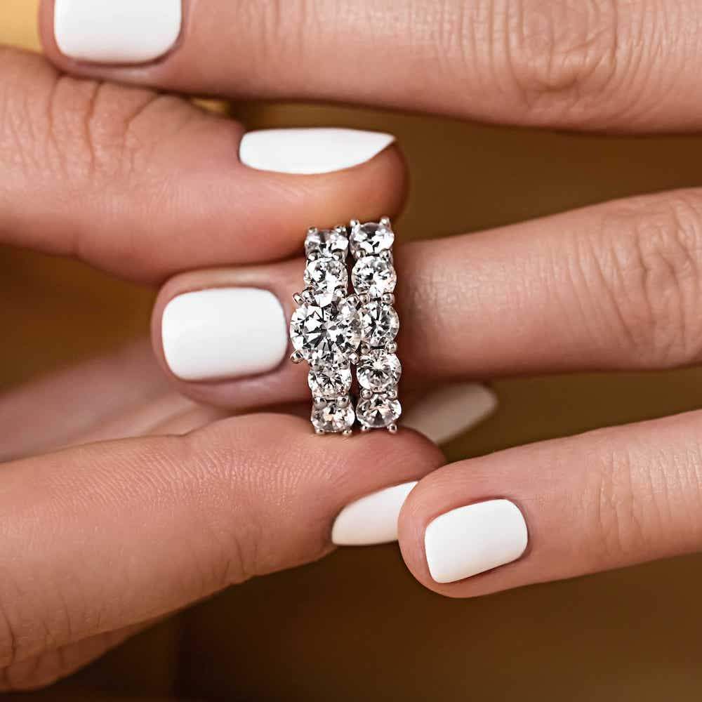 Shown with a 1ct Round Cut Lab Grown Diamond Center Stone amid four 0.25ct Diamond Hybrids in 14k White Gold|Accented engagement ring with a 1ct round cut lab grown diamond amid diamond hybrid simulants totaling 1ctw in 14k white gold