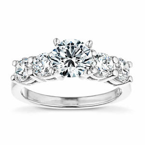 Accented engagement ring with a 1ct round cut lab grown diamond amid diamond hybrid simulants totaling 1ctw in 14k white gold