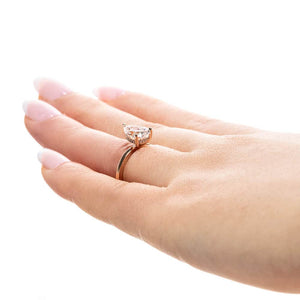 Hidden halo engagement ring with 1ct pear cut lab grown diamond in 14k rose gold band on hand