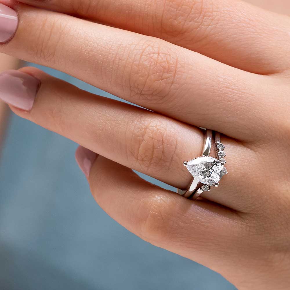 Shown with a 1.0ct Pear cut Lab-Grown Diamond with a hidden halo in recycled 14K white gold with matching wedding band | wedding set hidden halo diamond accented recycled 14k white gold 1.0ct pear cut lab-grown diamond