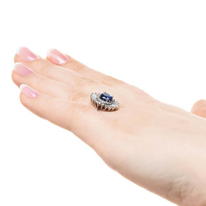 Unique stunning vintage style diamond halo engagement ring with baguette cut diamonds surrounding a 1ct round cut lab grown blue sapphire in 14k white gold worn on hand sideview