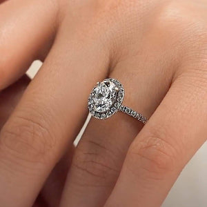 Dream diamond halo engagement ring with diamond accents and a 1ct oval cut lab grown diamond in platinum worn on hand