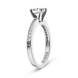 Diamond accented engagement ring with channel set diamonds and a 1ct round cut lab grown diamond set in 14k white gold shown from side