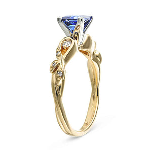 Nature inspired design engagement ring with diamond accented band and a 1ct princess cut lab created blue sapphire in 14k yellow gold shown from side