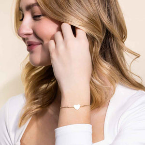 Woman wearing Petite paperclip chain bracelet with engravable heart in 14 carat yellow gold by MiaDonna