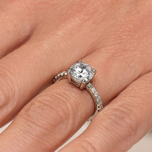 Diamond accented engagement ring with 1.5ct round cut lab grown diamond in platinum setting shown worn on hand