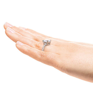 Diamond accented engagement ring with 1.5ct round cut lab grown diamond in platinum shown worn on hand sideview