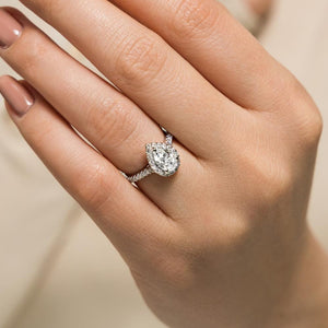 Beautiful diamond accented halo tear drop engagement ring with 1ct pear cut lab grown diamond in 14k white gold shown worn on hand