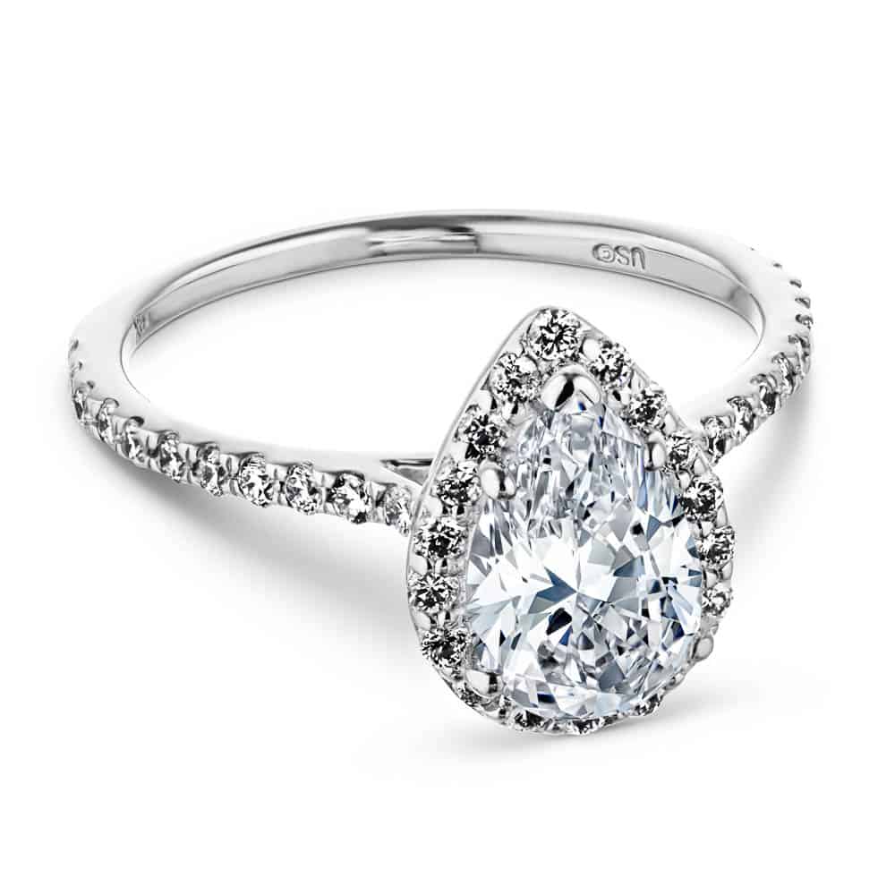 Shown with a 1.0ct Pear cut Lab-Grown Diamond with a diamond accented halo and band in recycled 14K white gold 
