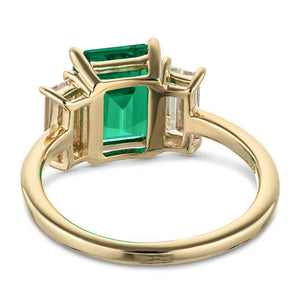 Three stone basket set engagement ring with green emerald and yellow gold shown from back