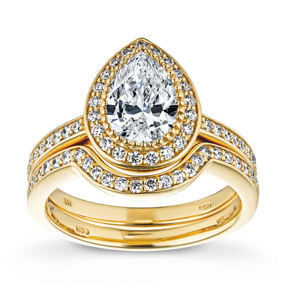 Shown with a 1.0ct Pear cut Lab-Grown Diamond with a diamond accented halo and band in recycled 14K yellow gold with matching wedding band 