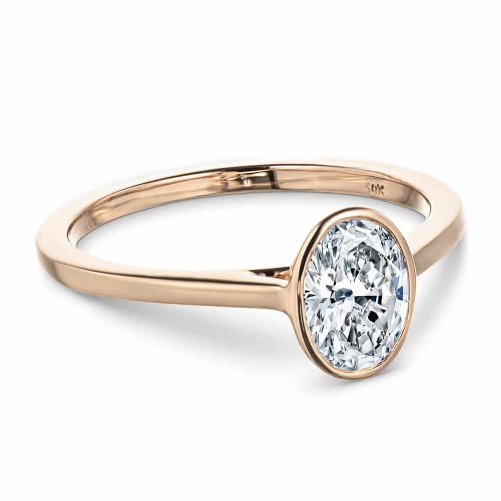 Shown with 1ct oval cut lab grown diamond in 14k rose gold|Minimalistic sleek modern flat design stackable engagement ring with 1ct bezel set oval cut lab grown diamond in 14k rose gold