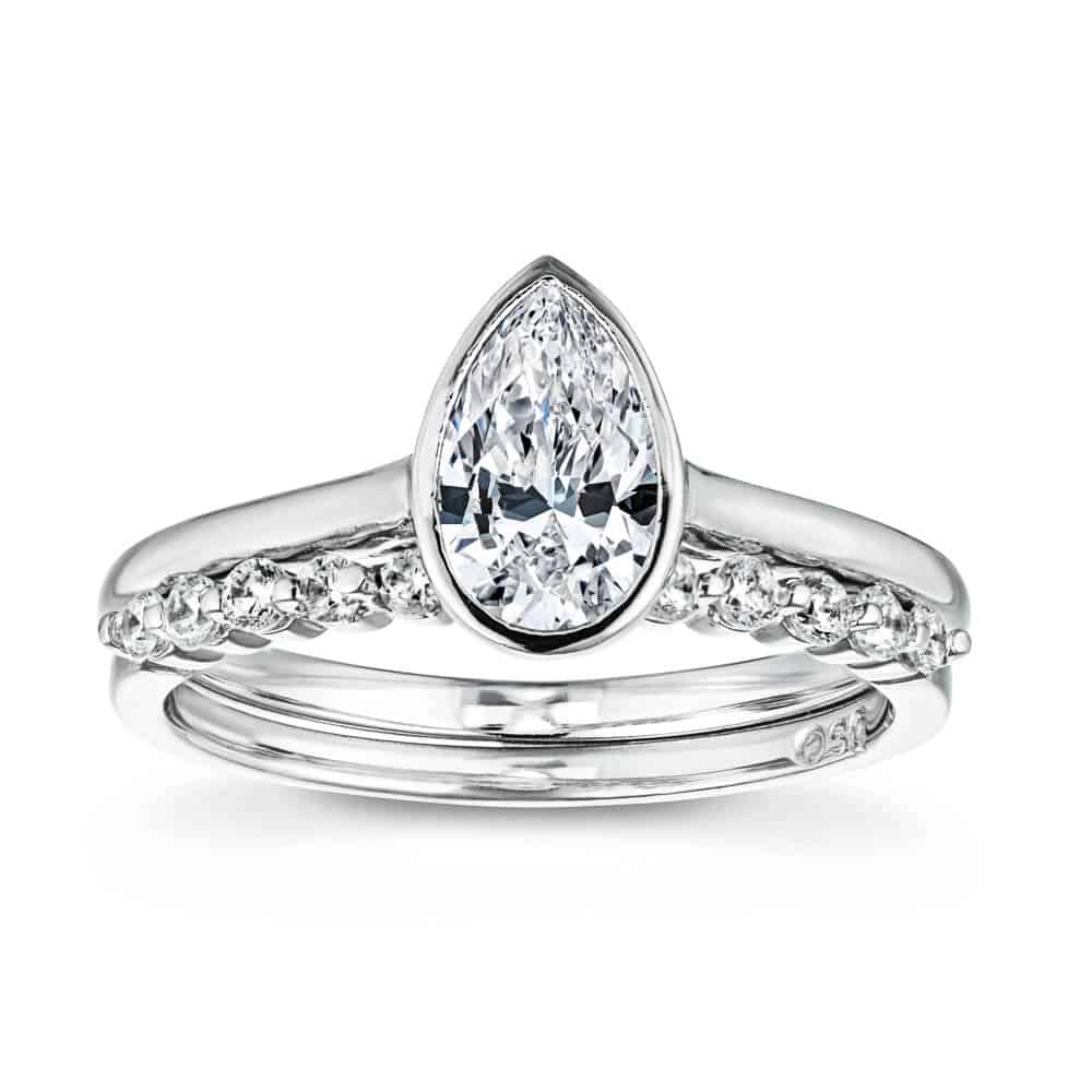 Shown with a bezel set 1.0ct Pear cut Lab-Grown Diamond in recycled 14K white gold with matching wedding band, can be purchased together for a discounted price