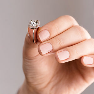 Gorgeous diamond accented halo engagement ring with 2ct round cut lab grown diamond in 14k rose gold shown held in hand