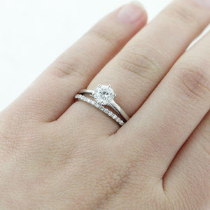 Crown style solitaire engagement ring with 6 prong set 1ct round cut lab grown diamond in 14k white gold worn on hand with stackable diamond accented band