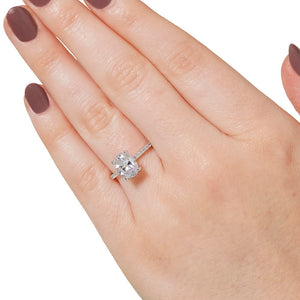 Diamond accented hidden halo engagement ring with 1.5ct oval cut lab grown diamond in 14k white gold worn on hand