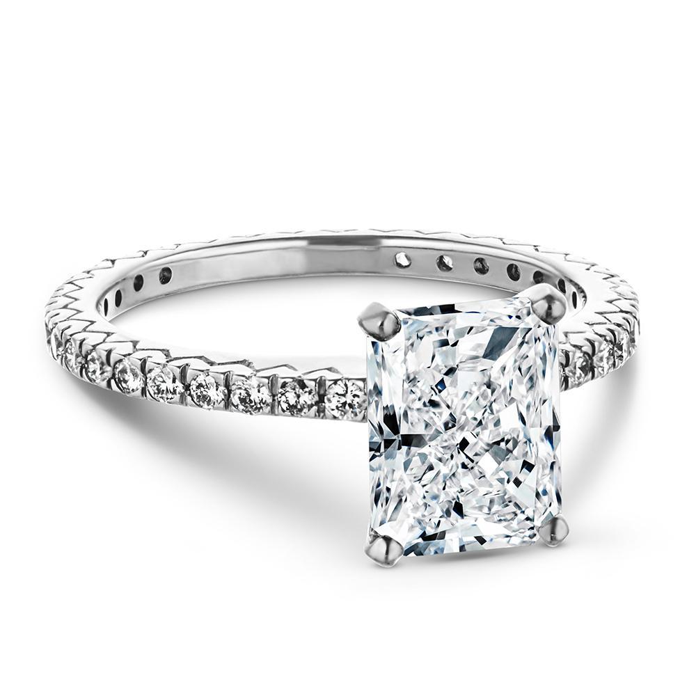 Shown with a 1.0ct radiant cut Lab-Grown Diamond with recycled diamonds that go approximately 3/4 around the slightly squared band in recycled 14K white gold 