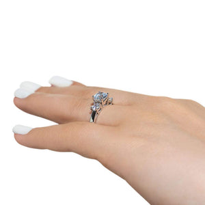 Three stone engagement ring with prong and basket set round lab diamonds in 14k white gold worn on hand sideview