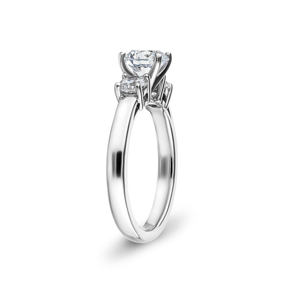 Shown with one 1ct and two 0.5ct Round Cut Lab Grown Diamonds in 14k White Gold|Elegant three stone ring with 1ct round cut lab grown diamond and two diamond shoulder stones in 14k white gold
