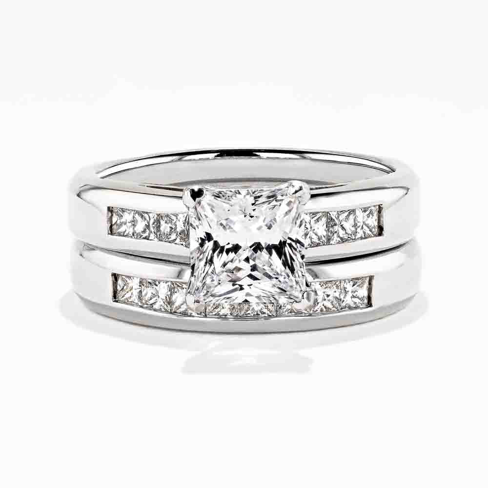 Melanie Wedding Set featuring a princess cut 1.50ct Diamond Hybrid® engagement ring in recycled 14K white gold with .30ctw side stones and a matching wedding band with .40ctw channel set stones 