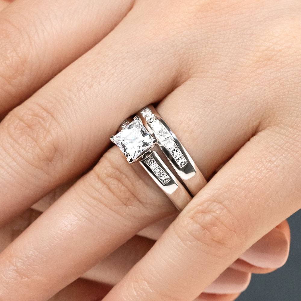 Shown with a 1.0ct Princess cut Lab-Grown Diamond with channel set accenting diamonds in recycled 14K white gold with matching wedding band, can be purchased together for a discounted price 