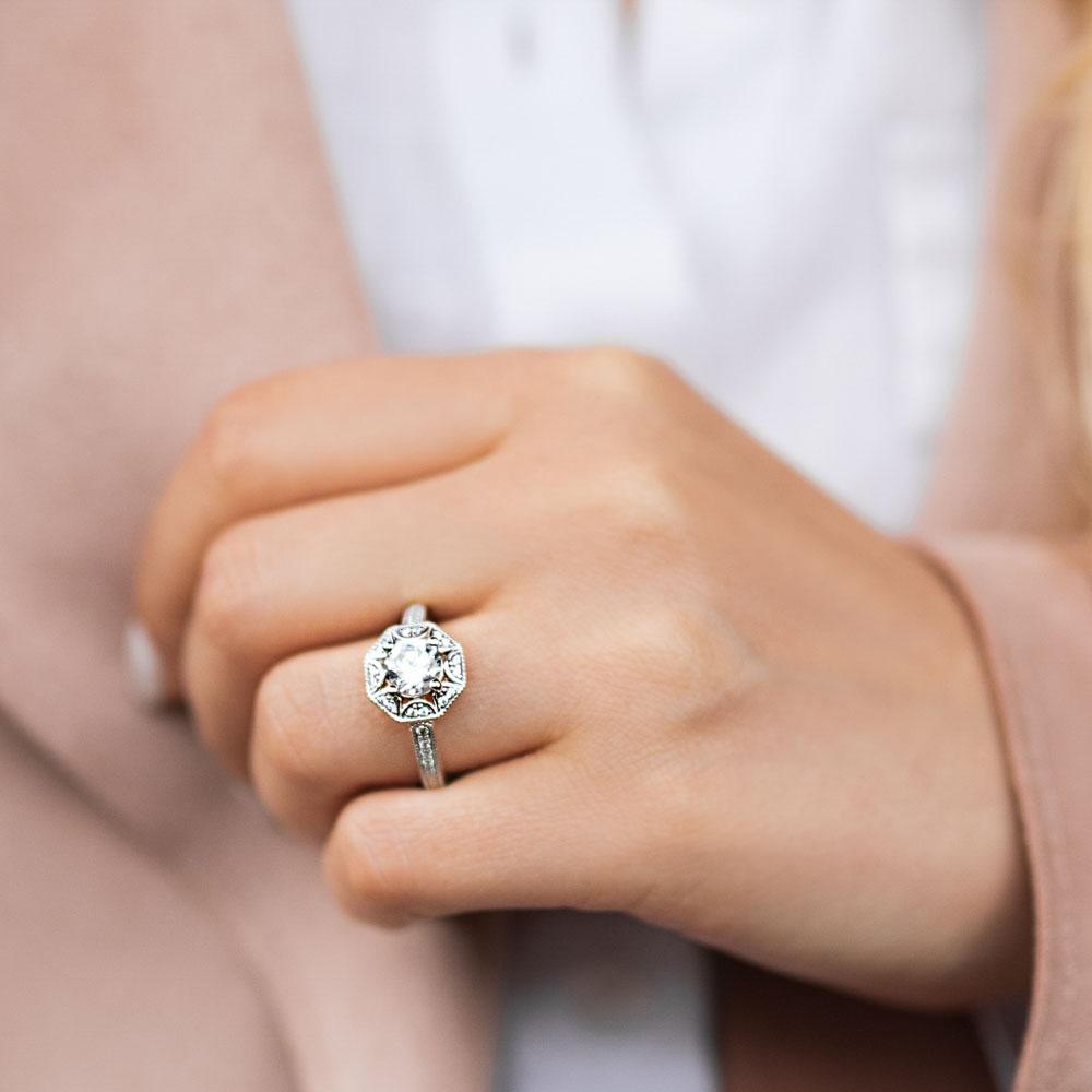 Shown with 1ct Round Cut Lab Grown Diamond in 14k White Gold|Vintage antique style diamond accented halo engagement ring with filigree and milgrain detailing holding a 1ct round cut lab grown diamond in 14k white gold