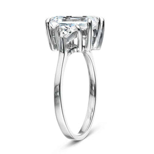 Three stone engagement ring with 2ct emerald cut lab grown diamond center stone with triangle side stones set in 14k white gold band shown from side