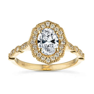 Romantic antique style diamond accented halo Paris engagement ring with a 1ct oval cut lab grown diamond set in filigree and milgrain detailed 14k yellow gold band