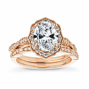 Vintage style rose gold wedding ring set inspired by Paris design featuring filigree detailing around diamond accented band and halo with a 1ct oval cut lab grown diamond