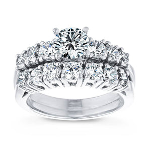  engagement ring diamond accented Shown with a 1.0ct Round cut Lab-Grown Diamond with six accenting stones on the band in recycled 14K white gold with matching wedding band
