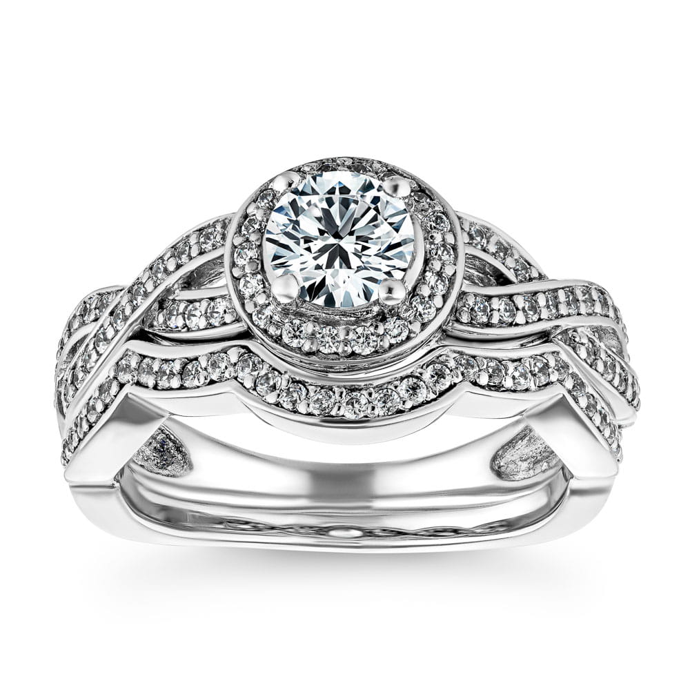 Shown with a 1.0ct Round cut Lab-Grown Diamond with a diamond accented halo and twisted band in recycled 14K white gold with matching wedding band 