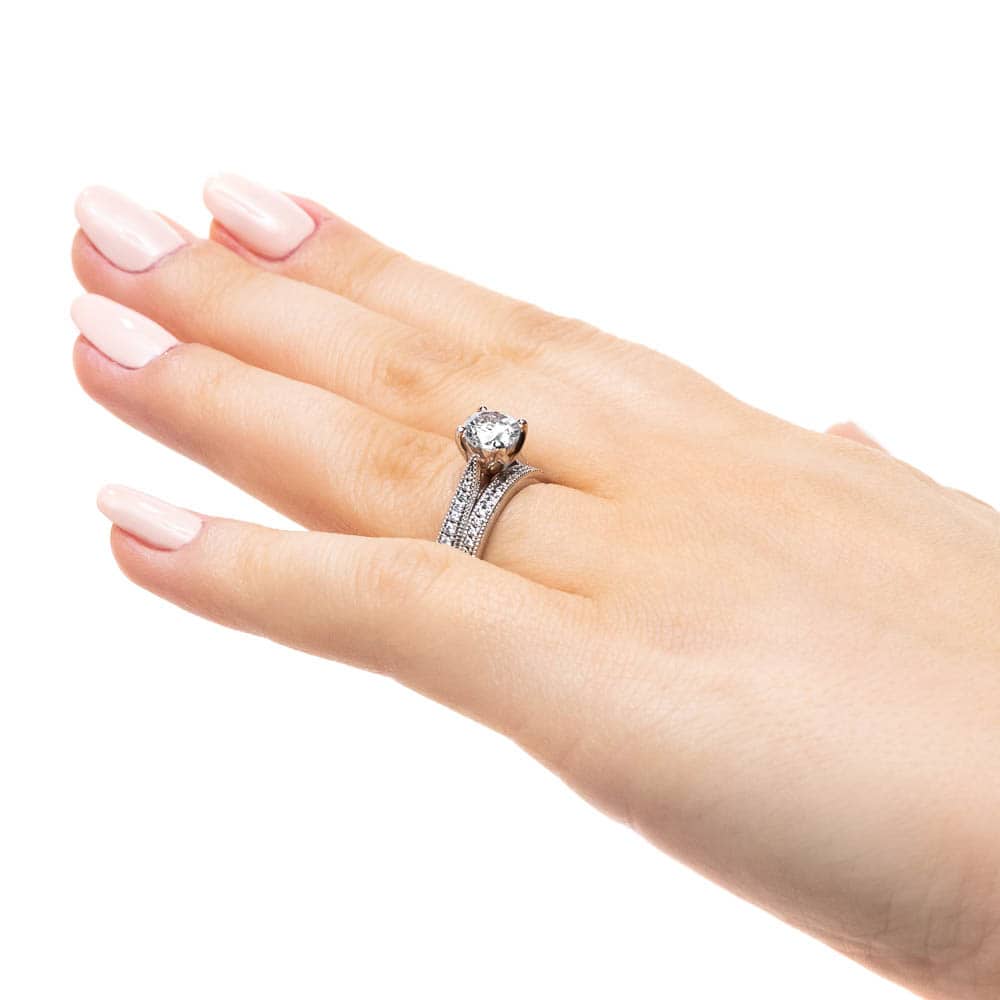 Shown with a 1.0ct Round cut Lab-Grown Diamond with diamonds accenting the band and filigree details in recycled 14K white gold with matching wedding band, can be purchased together for a discounted price