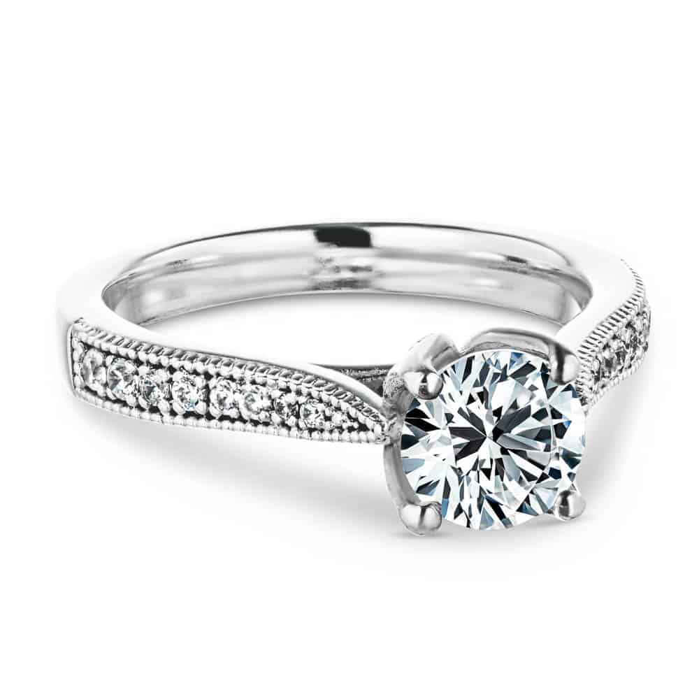 Shown with a 1.0ct Round cut Lab-Grown Diamond with accenting diamonds on the band and filigree details in recycled 14K white gold 