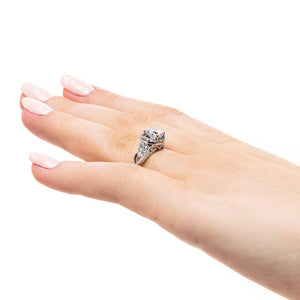 Vintage style diamond accented halo engagement ring with 1ct round cut lab created diamond with milgrain and filigree detailing in two tone 14k white gold worn on hand sideview