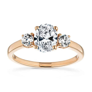 Stunning ethical three stone engagement ring with 1ct oval cut lab grown diamond and two round cut lab diamond shoulder stones in basket style 14k rose gold setting