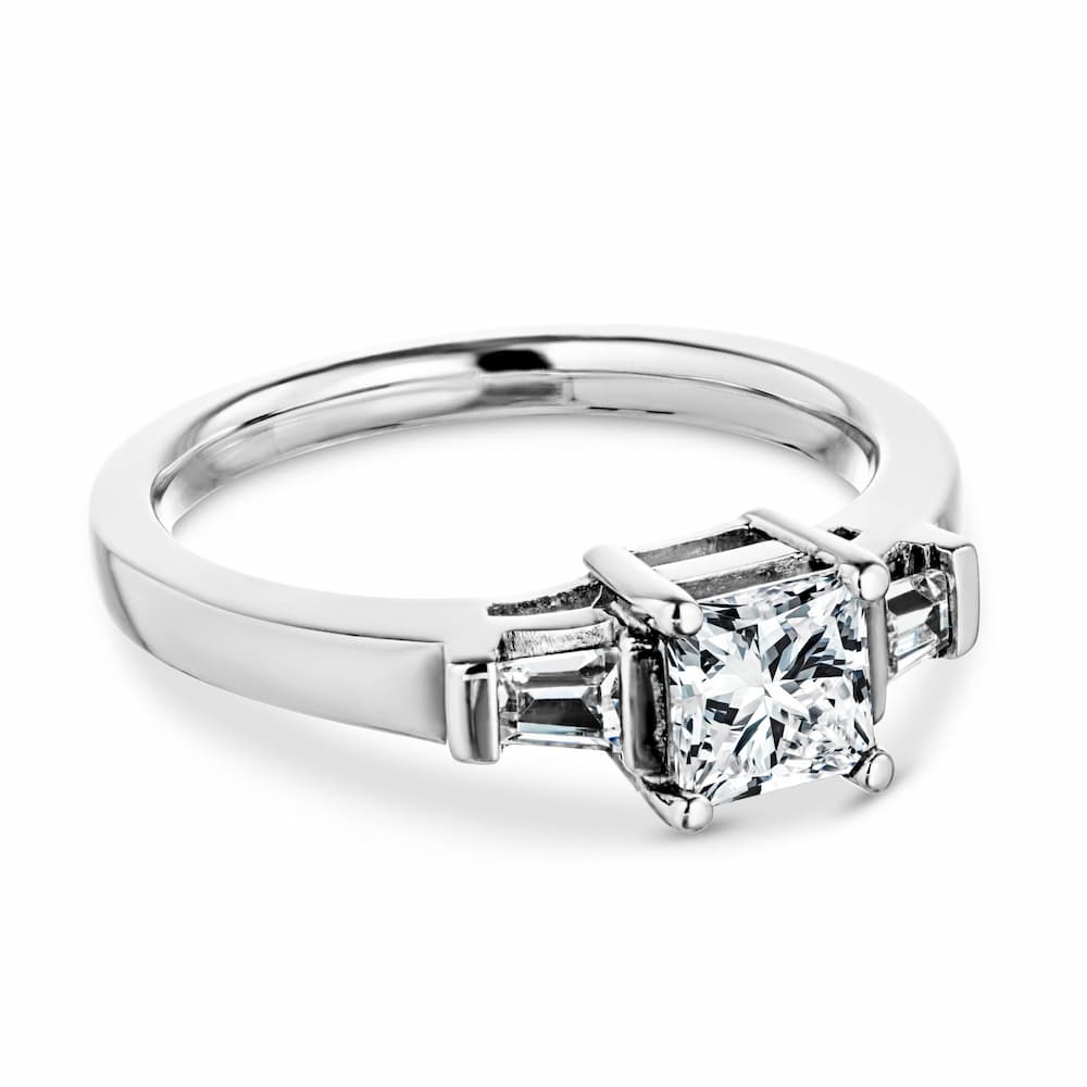Shown with 1ct Princess Cut Lab Grown Diamond in 14k White Gold|Unique modern three stone engagement ring with 1ct princess cut lab created diamond and two tapered baguette side stones in cathedral style 14k white gold setting