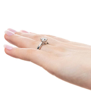 Solitaire engagement ring with 1ct round cut lab grown diamond in cathedral style 14k white gold band worn on hand sideview
