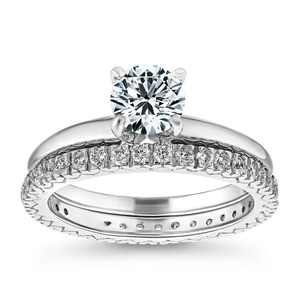 Traditional Solitaire Engagement Ring shown with a 1.0ct Lab-Grown Diamond in recycled 14K white gold paired with the Marilyn Wedding Band that is accented with recycled diamonds three quarters of the way around the shank. 